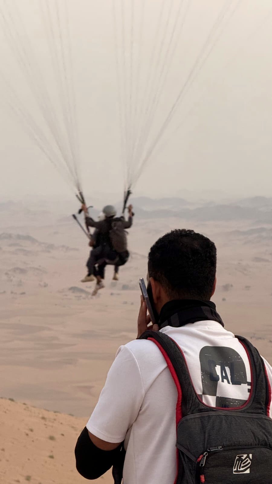 عضو من فريق الطيران يتابع رحلة ترادفية فوق الصحراء